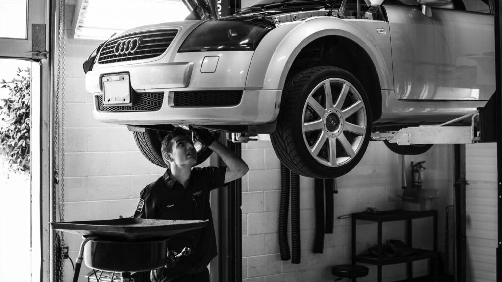 Tech inspecting Audi on lift
